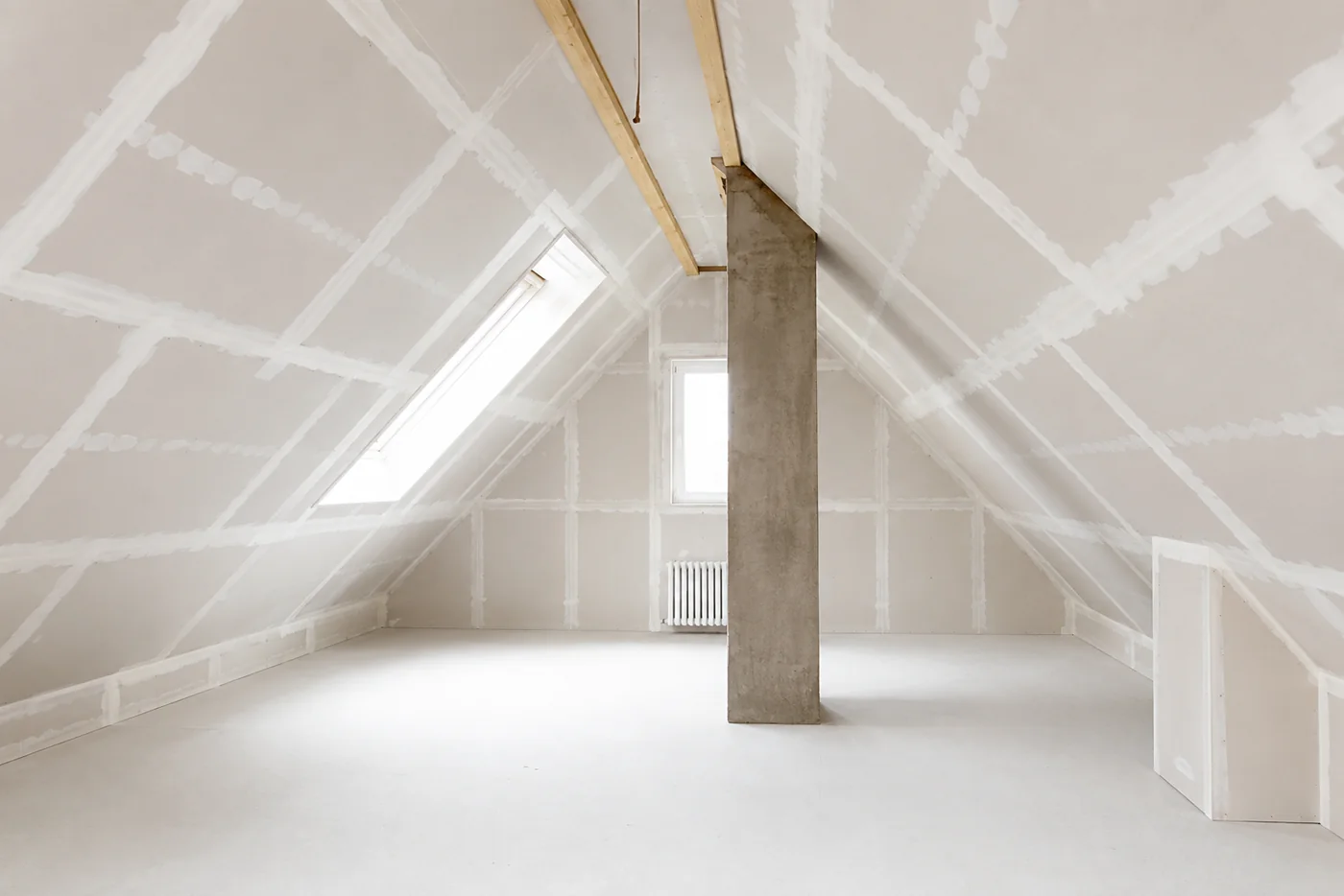 Ausgebautes Dachgeschoss in Trockenbau: verspachtelte Gipsplatten, Dachflächenfenster und freistehende Betonstütze