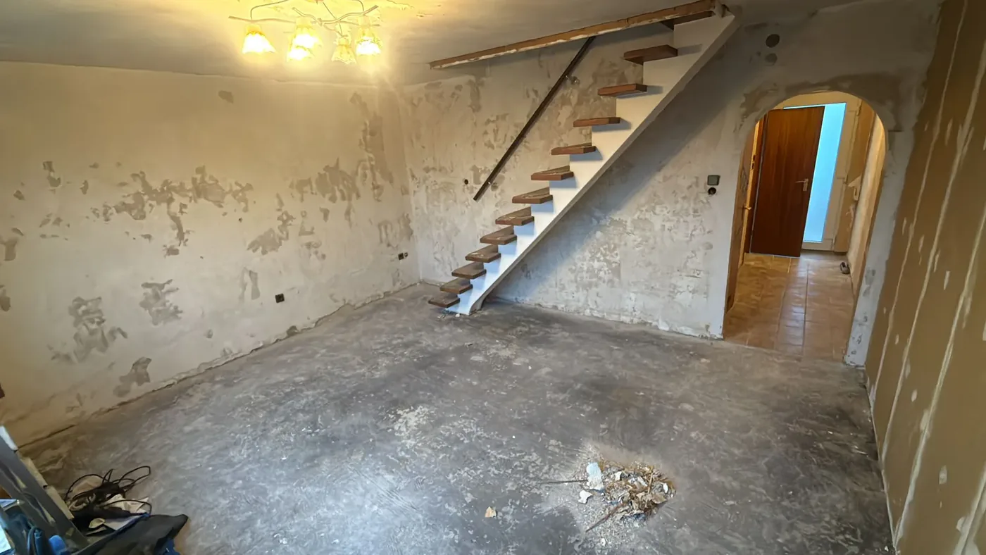 Treppenaufgang der Maisonette-Wohnung in Stockum vor der Renovierung mit abgeschlagenem Putz